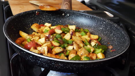 Mixed-vegetable-and-potatoes-cooking-in-frying-pan-at-home,-closeup