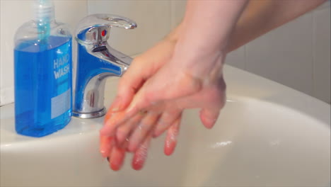 Turning-on-tap-and-dispensing-soap-to-properly-wash-hands-at-sink,-time-lapse
