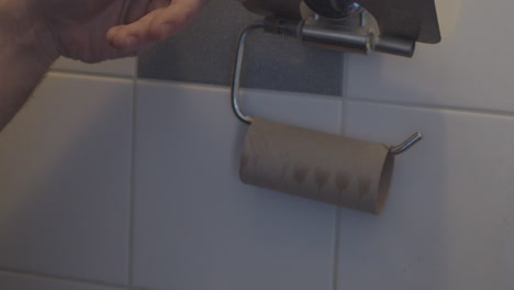 Hand-Greifen-Letztes-Blatt-Toilettenpapier-Auf-Rolle-Im-Badezimmer