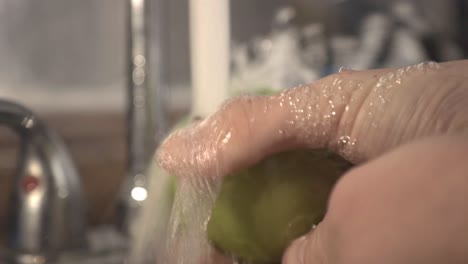 Sorgfältiges-Waschen-Des-Grünen-Apfels-Mit-Beiden-Händen-Unter-Fließendem-Wasser
