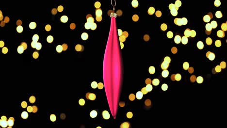 single-red-Christmas-cone-ornament-with-out-of-focus-lights-flickering-in-the-background,-close-up
