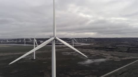 Nachhaltige-Elektrische-Windkraftanlagen,-Die-Sich-Auf-Englands-Ackerland-Drehen,-Schließen-Die-Umlaufbahn-Langsam-Nach-Rechts
