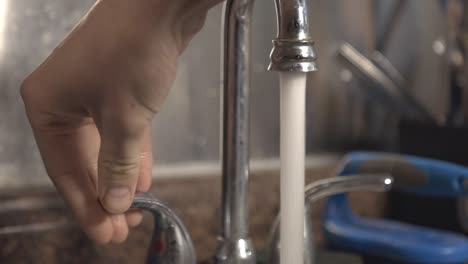 Turning-On-The-Water-From-The-Faucet-In-The-Kitchen-Sink