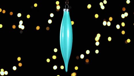 Einzelnes-Blau-türkises-Weihnachtskegel-Ornament-Mit-Unscharfen-Lichtern,-Die-Im-Hintergrund-Flackern,-Nahaufnahme