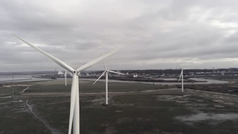 Nachhaltige-Elektrische-Windturbinen,-Die-Sich-Auf-Englands-Ackerland-Drehen,-Parallax-Dolly-Rechts