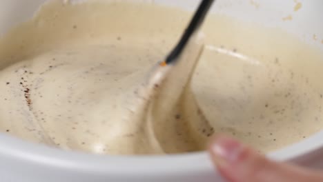 Making-gluten-free-flourless-almond-chocolate-cake,-stirring-creamy-beaten-eggs-with-ground-chocolate-and-almond-using-spatula