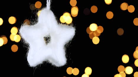 Einzelne-Gehäkelte-Flauschige-Weiße-Stern-Weihnachtsverzierung-Mit-Unscharfen-Lichtern,-Die-Im-Hintergrund-Flackern,-Nahaufnahme