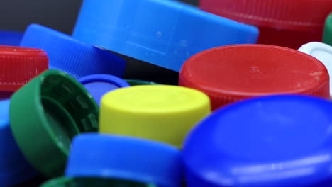 Haufen-Mehrfarbiger-Plastikkappen-Zum-Recycling,-Die-Sich-Langsam-Drehen,-Geringe-Schärfentiefe