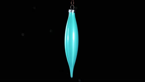 single-blue-turquoise-Christmas-cone-ornament-with-black-background,-close-up