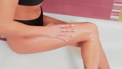 Closeup-Mädchen-Reibt-Ihre-Füße-Im-Badezimmer-Mit-Creme-Peeling