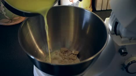 Poring-milk-over-yeast-in-a-bowl-to-begin-preparing-the-bread-dough