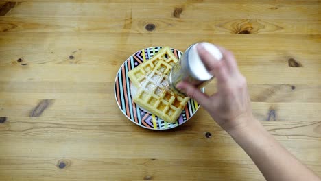 spreading-sugar-powder-on-two-waffles