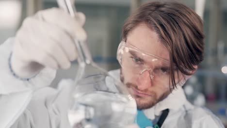 scientist-in-the-laboratory-examines-a-flask-with-water