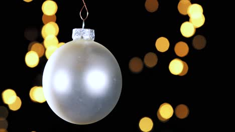 Single-Silver-Christmas-Ball-Ornament-Mit-Unscharfen-Lichtern,-Die-Im-Hintergrund-Flackern,-Nahaufnahme