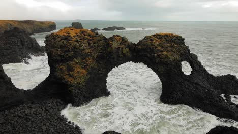 The-beautiful-black-rock-arch-formation-at-Diamond-Beach-in-Iceland-by-the-sea---wide-shot