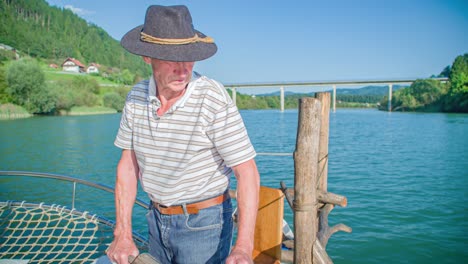 Adventurous-grandpa-rowing-a-log-raft-at-Muta,-Slovenia-in-slow-motion