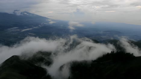 Vista-Aérea-Tiro-En-Movimiento,-Vista-Escénica-Subiendo-Nieblas-Que-Cubren-La-Colina-De-Pergasingan-En-Lombok-Indonesia