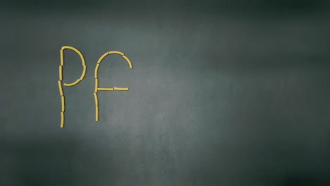 Stop-motion-of-writing-pasta-word-on-a-black-slate-background-with-macaroni-type-pasta
