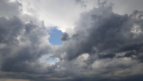 Blue-summer-sky-with-dense-thick-rain-clouds-moving-across-the-heavens