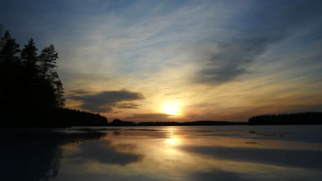 Atemberaubender-Zeitraffer-Von-Wasserreflexionen-Auf-Dem-Eisigen-See-Bei-Farbenfrohem-Sonnenuntergang