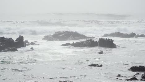 Rocky-Shoreline-on-Misty-Day-with-White-Waves-Crashing-Against-Rocks