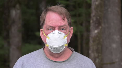 An-Adult-Man-Wearing-N95-Face-Mask-To-Protect-Himself-While-In-The-Forest-In-Bandon,-Oregon---Zoom-in-Shot