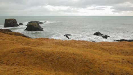 Die-Schönen-Wellen-Von-Island-Durch-Die-Braune-Berglandschaft-Und-Die-Felsige-Küste---Weit-Geschwungen