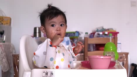 Süßes-Einjähriges-Asiatisches-Mädchen,-Das-Löffel-Isst-Und-Leckt,-Nachdem-Es-Gebratenes-Mee-Gegessen-Hat
