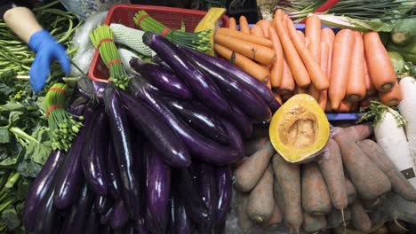A-market-vendor-prepare-vegetables-such-eggplants,-carrots-and-others-for-sale-in-Hong-Kong
