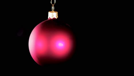 single-red-Christmas-ball-ornament-with-black-background,-close-up