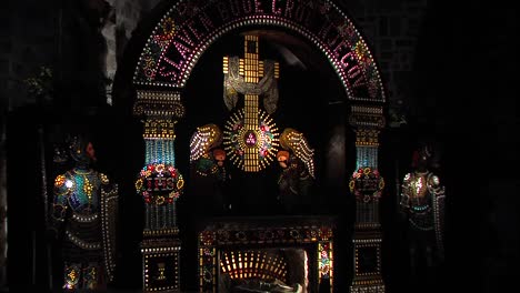 Illuminated-wooden-replica-of-god's-grave-in-Slovenian-church,-zoom-out