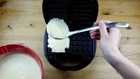 putting-waffle-dough-into-a-waffle-iron