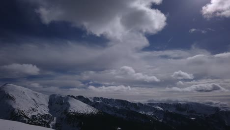 Un-Lapso-De-Movimiento-De-Algunas-Montañas-Nevadas-Con-Nubes-Asombrosas-Sobre-Ellas