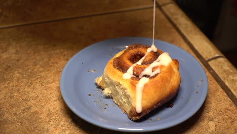 Cinnamon-Bread-Topped-With-Icing-Dripping-In-Slow-Motion---Closeup-Shot