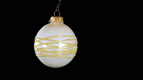 Single-White-Christmas-Ball-Ornament-Mit-Goldenen-Glitzerstreifen-Und-Schwarzem-Hintergrund,-Nahaufnahme