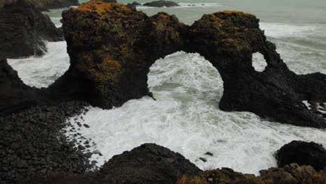 Seeing-the-stunning-arch-rock-formation-by-the-waves-of-Iceland---tilt-up