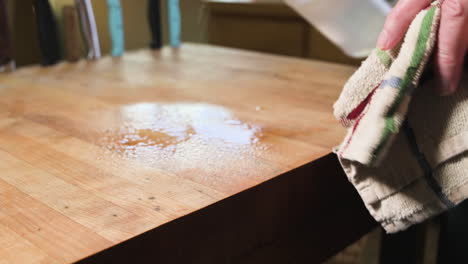Spraying-solution-on-a-wooden-table-to-clean-it---close-up