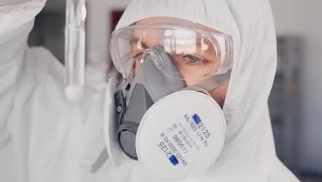 Wissenschaftler-In-Einem-Schutzanzug-Und-Einem-Atemschutzgerät,-Das-Eine-Substanz-In-Einem-Reagenzglas-Untersucht