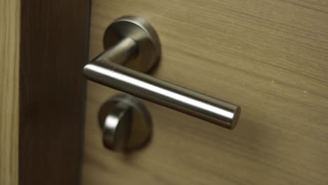 Close-up-of-spraying-a-metal-door-handle-with-detergent-and-disinfectant-to-clean-it