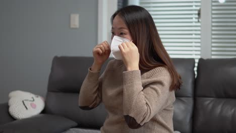 Asiatische-Schwangere-Setzen-Zu-Hause-Eine-Schutzmaske-Gegen-Grippe-Und-Viren-Auf