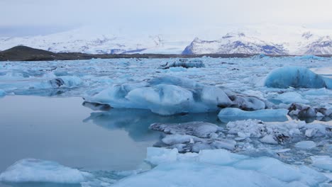 Ein-Wunderschöner,-Bläulich-weißer-Eisberg,-Der-In-Einem-See-In-Island-Schwimmt---Weitschuss