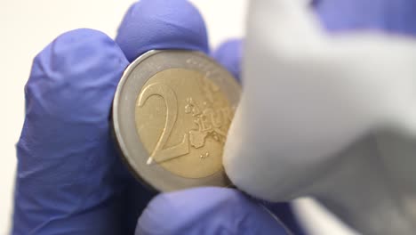 Isolated-close-shot-of-front-two-euro-coin-wiped,-coronavirus