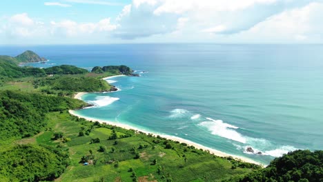 Aerial-wide-vivid-landscape-where-the-ocean-meets-the-land,-tropical-beach-with-open-blue-sky,-clear-horizon-at-the-end-of-the-world