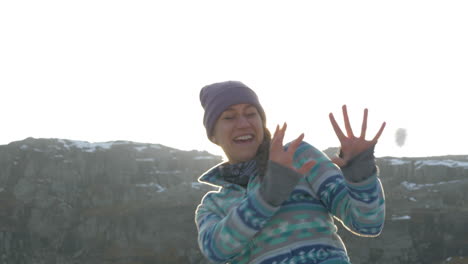 A-Woman-in-a-Snowball-Fight-During-Sunset-on-top-of-a-Mountain-in-Norway,-Slow-Motion