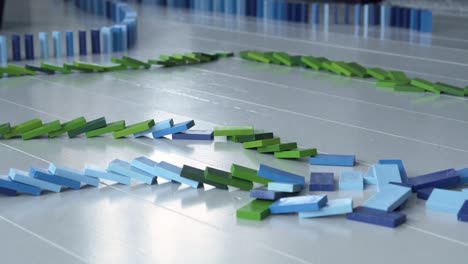 Long-dominoes-line-falling-down,-blue-and-green-domino-blocks