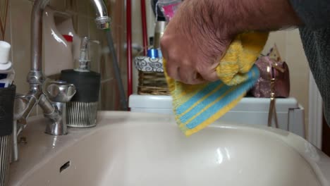 Man-in-quarantine-wiping-his-wet-hands-with-a-towel-after-washing