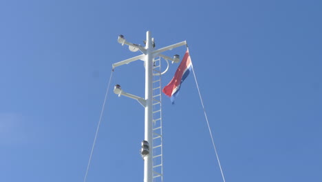 A-Norwegian-Ferry-Flag-Waving-on-top-of-a-Mast-on-a-Bright-Sunny-Day,-Slow-Motion