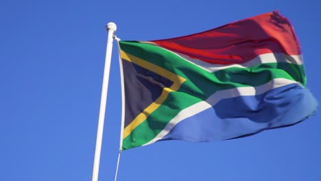 Südafrikanische-Flagge-Weht-In-Zeitlupe-Im-Wind-Unter-Blauem-Himmel