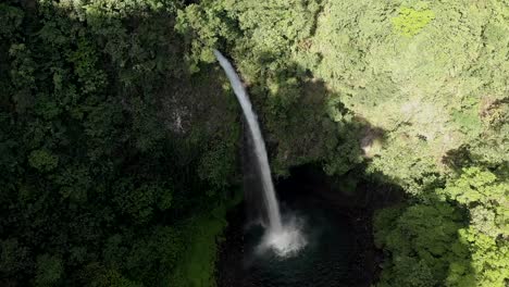 Beautiful-aerial-view-of-the-La-Fortuna-waterfall-in-Costa-Rica,-with-nature-all-around-it-and-popping-colors-everywhere
