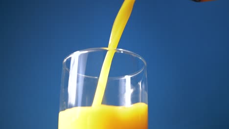 Orangensaft-Wird-In-Zeitlupe-In-Ein-Glas-Gegossen